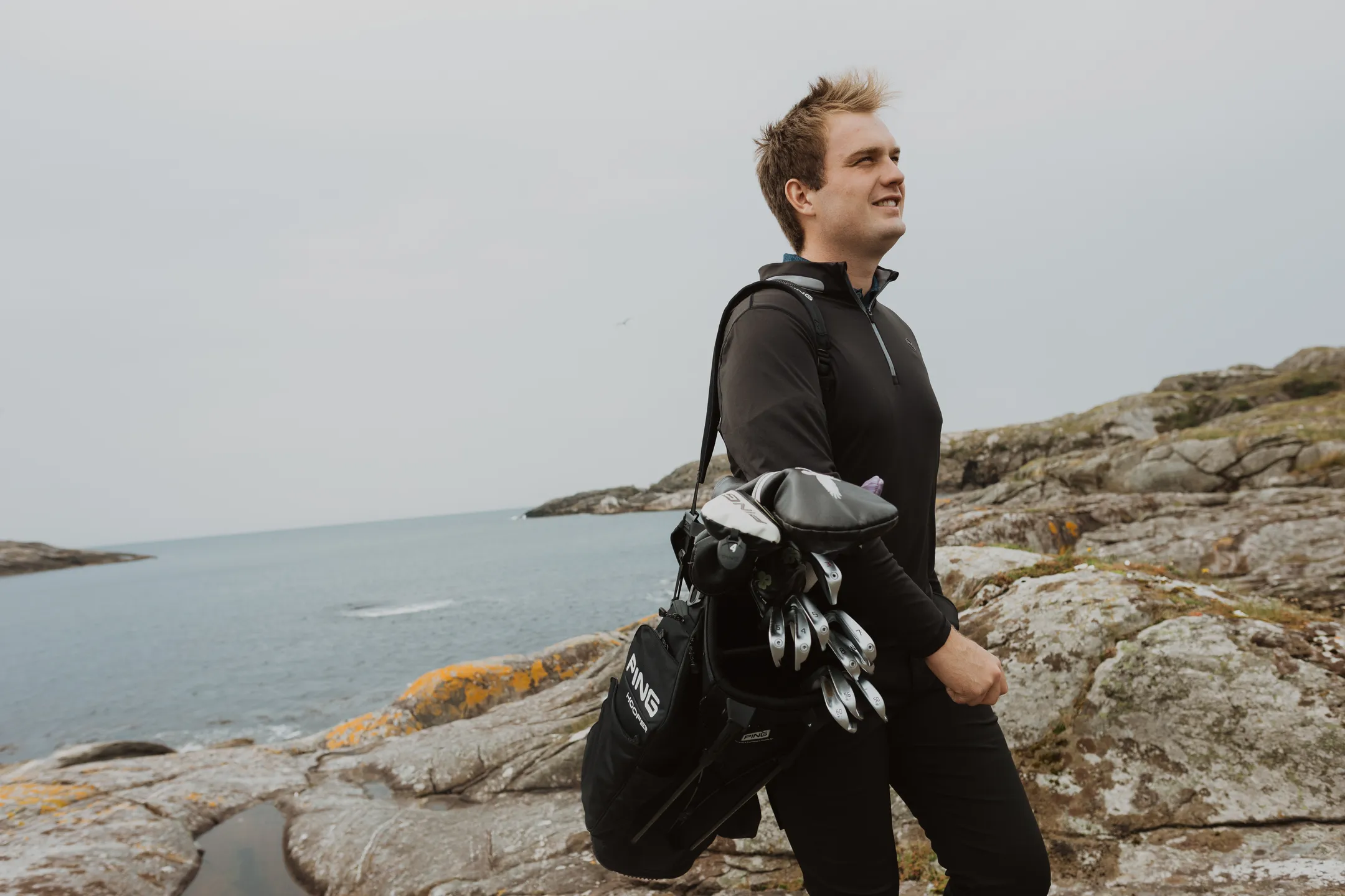 Bård standing with his golf set on his shoulder