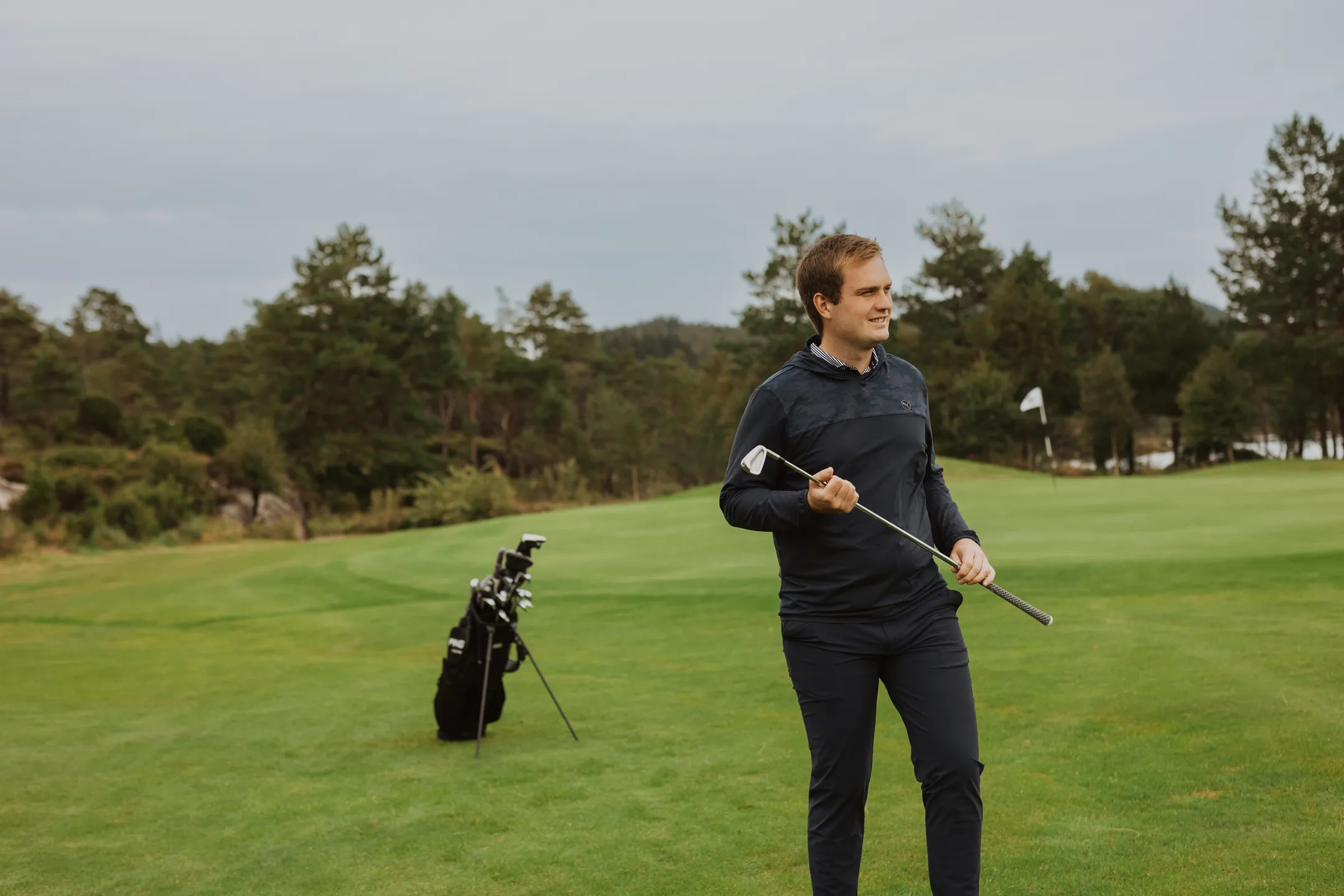 Bård on the golf course holding an iron club in both hands