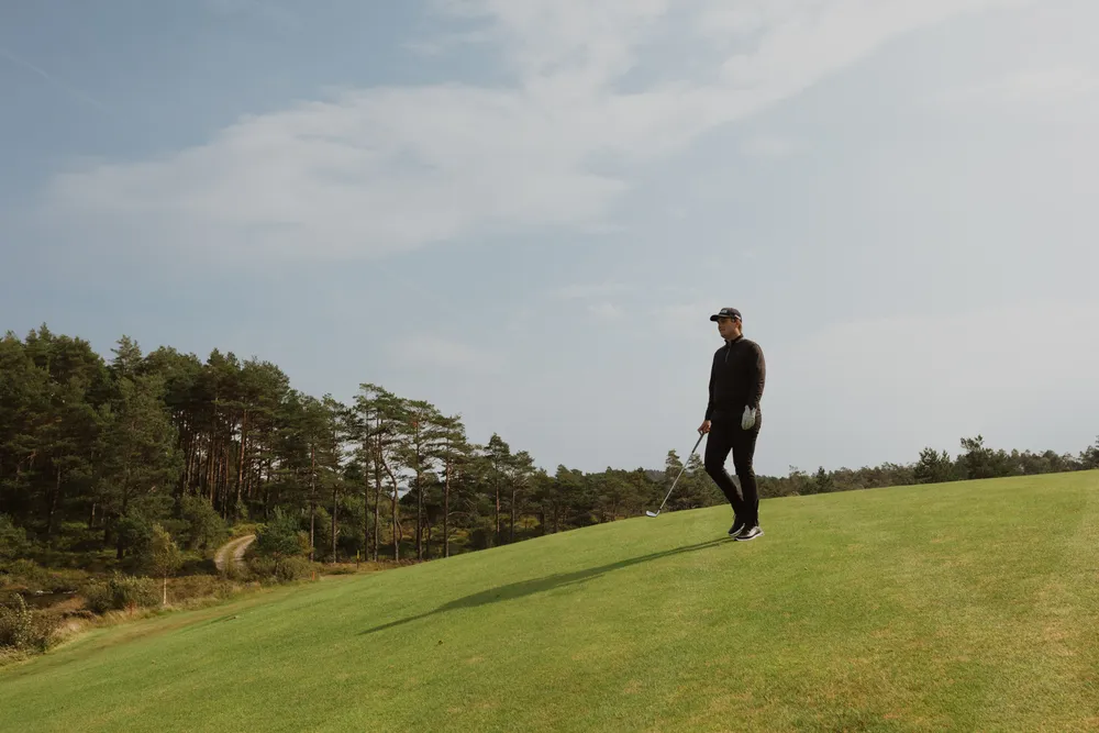 Bård walking down the hillside on the golf course