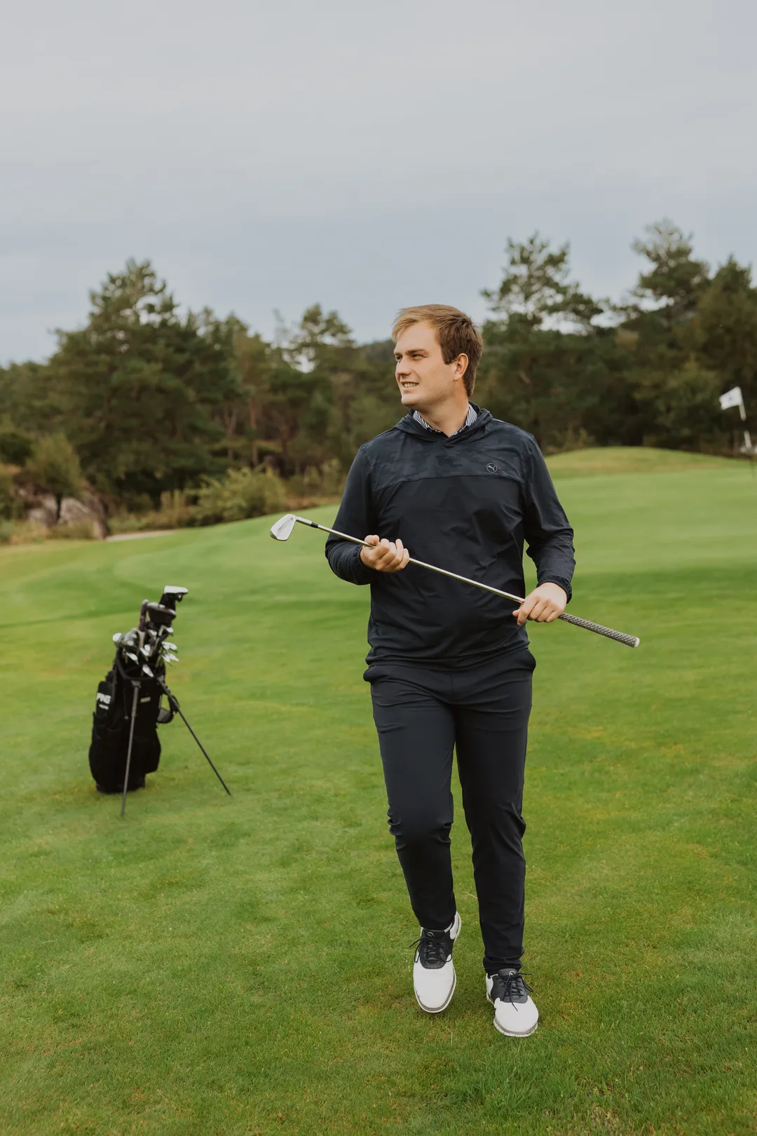 Bård standing on the golf course with an iron club