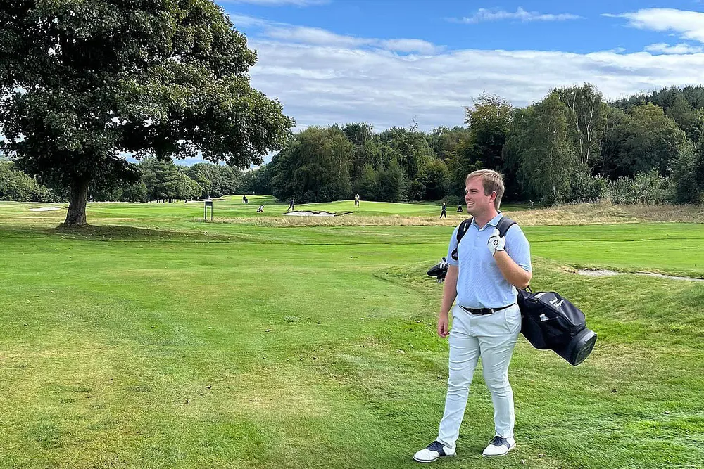 Bård standing on the golf course with his golf bag on the back